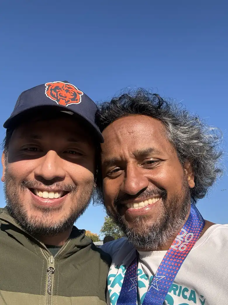 Chatterpaul smiling with a supporter after the Chicago Marathon, wearing his finisher medal