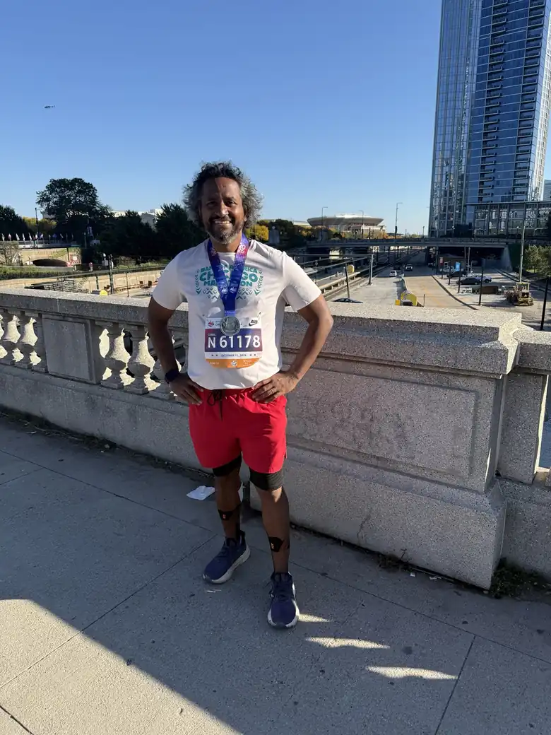 Chatterpaul smiling with his Chicago Marathon finisher medal and bib number 61178