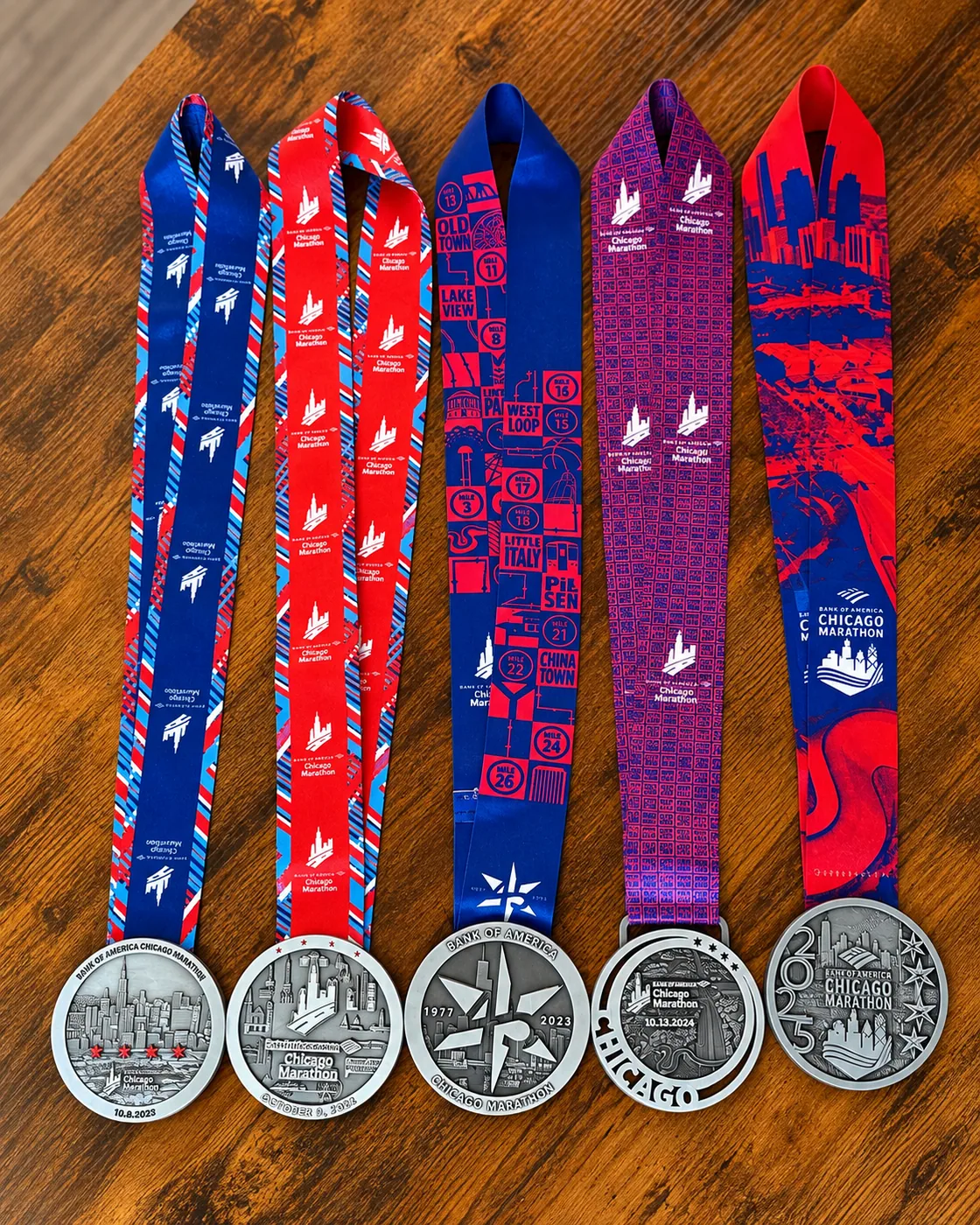 Five Chicago Marathon medals displayed on a wooden table